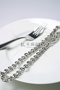 盘子上叉子旁边的一条银链