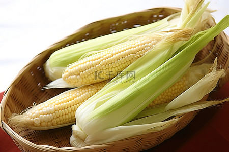 竹背景图片_坐在竹篮里的四个白色玉米穗
