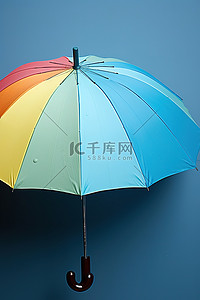 雨伞背景图片_蓝色墙上的一把雨伞，上面有水滴