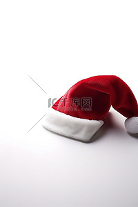 红色的帽子背景图片_白色表面上的红色圣诞老人帽子