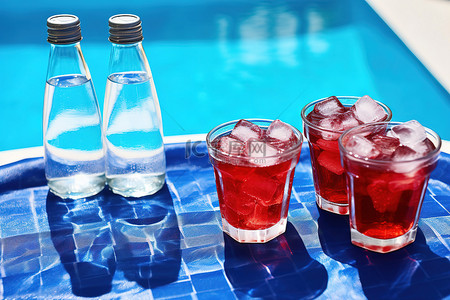 酒背景图片_蓝色水池旁边的三个瓶子和三个冰块