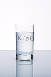一杯水坐在桌子上和白色背景上