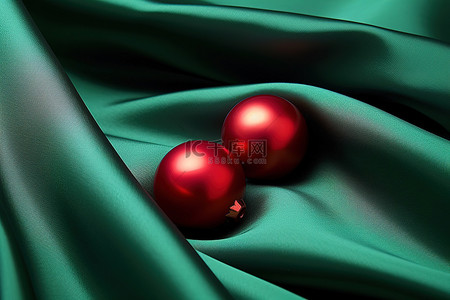 圣诞背景图片_绿色丝绸上的两个红色球