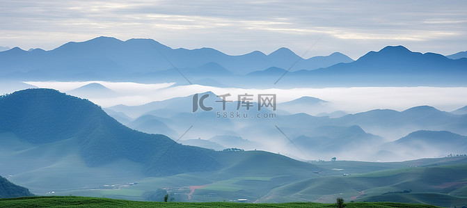 郁郁葱葱的绿色牧场，山景雾气和云彩