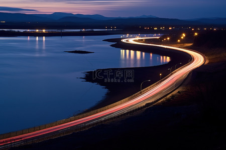 路背景图片_晚上靠近湖和水的桥上的一条路
