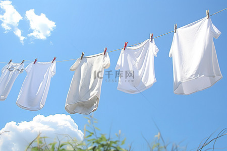 衣服挂拍背景图片_晴朗的天空下，白色挂在晾衣绳上