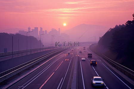 早晨的太阳背景图片_太阳从高速公路上冉冉升起，车辆驶过