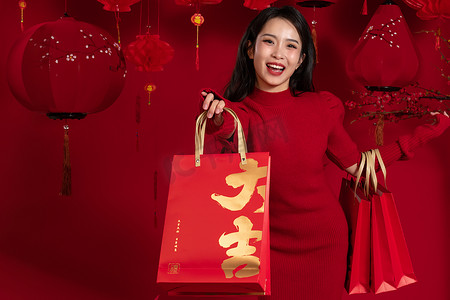 新年购物红色背景下的一位亚洲青年女性拿着购物袋