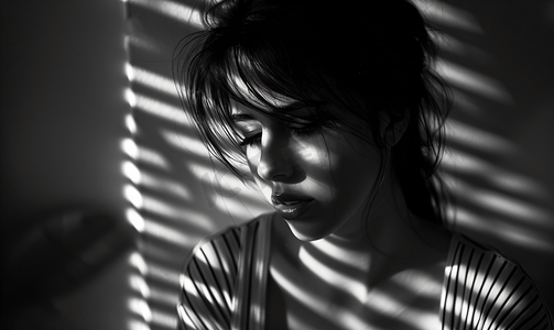 女性焦虑摄影照片_在黑暗中抑郁的人难过的女性