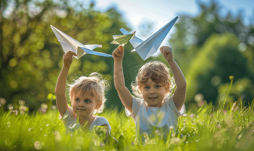 放飞梦想摄影照片_草地上玩纸飞机的孩子们