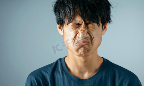 暴走漫画表情摄影照片_亚洲人面部表情痛苦的青年男人