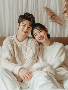 摄影照片_亚洲人年轻夫妻甜蜜的坐在床上