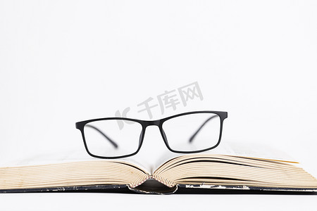 创意眼镜摄影照片_黑框眼镜打开的书本创意保护眼睛