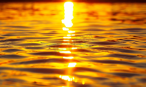 日落水在阳光下反射涟漪水面上日落的抽象金色反射