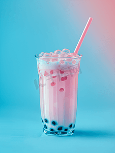 波巴摄影照片_蓝色背景玻璃中的泡沫波巴茶加牛奶和木薯珍珠