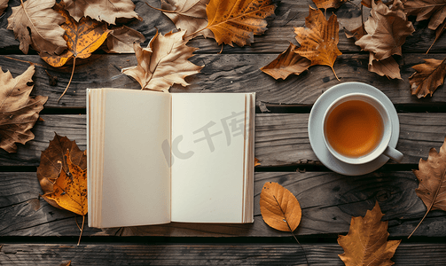 书茶摄影照片_旧桌子上放着秋叶和一杯热茶的白色空白书模型设计