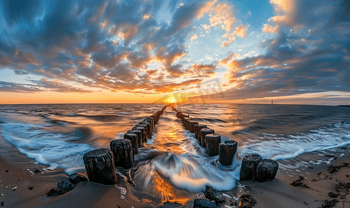 日落时沿着北海海滩米德尔克尔克防波堤的全景图像