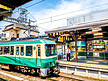 日本火车站的绿色小火车和铁轨摄影图