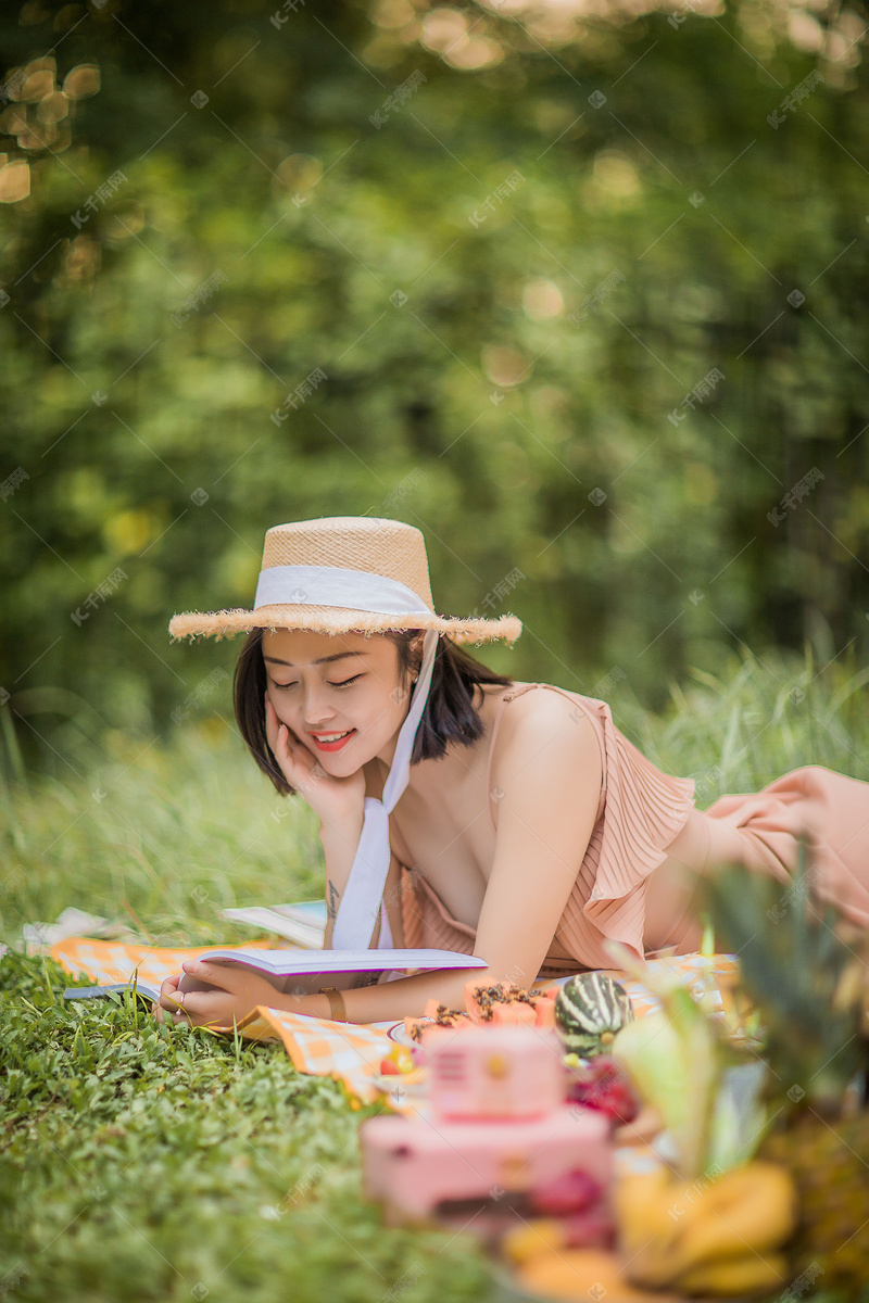 夏天户外野餐趴在地上看书的女孩