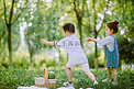户外草坪白天两个小朋友户外草坪吹泡泡摄影图配图
