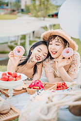 野餐郊游白天趴在地上的美女草地吐舌头摄影图配图