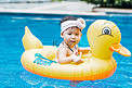 夏天儿童白天在泳池里漂浮的小女孩泳池游泳摄影图配图