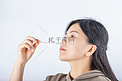 核酸自测白天拿着自测棉签的人室内沾取鼻腔样品摄影图配图