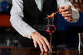 鸡尾酒晚上调酒师和一杯红色鸡尾酒酒吧装饰鸡尾酒摄影图配图