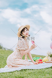 郊游野餐白天坐在草地上的美女草地喝酒摄影图配图