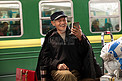 在火车站台上用手机的老人