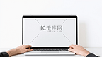 模拟图像空白屏幕电脑与白色背景的广告文字人手使用笔记本电脑联系业务搜索信息在办公桌上的办公室。市场营销与创意设计
