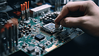 亚洲技术人员正在把中央处理器放在电脑主板的插座上。计算机硬件维修升级的概念和技术。