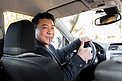 成功的商人汽车推销员驾驶方向盘的亚洲男性司机
