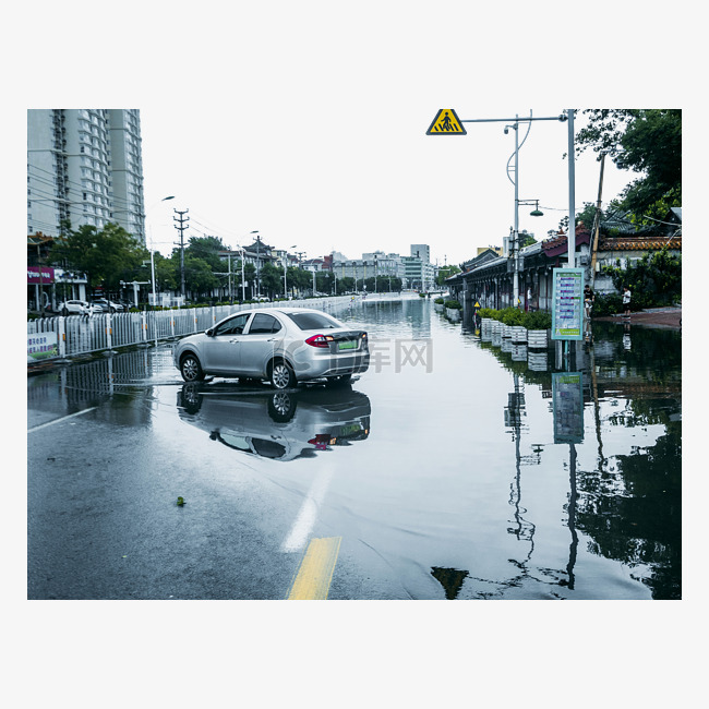 城市大雨雨水里的汽车在马路上停