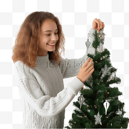 人在装饰圣诞树图片_穿着羊毛毛衣的快乐少女在家里装