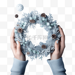 圣诞快乐花环图片_穿着冬季白色毛衣的女孩的手在蓝
