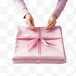 粉色圣诞礼盒图片_女手在桌子上用可重复使用的粉色