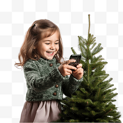 有圣诞树的小女孩用智能手机给自