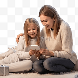 玩手机图片_妈妈和女儿坐在圣诞树附近