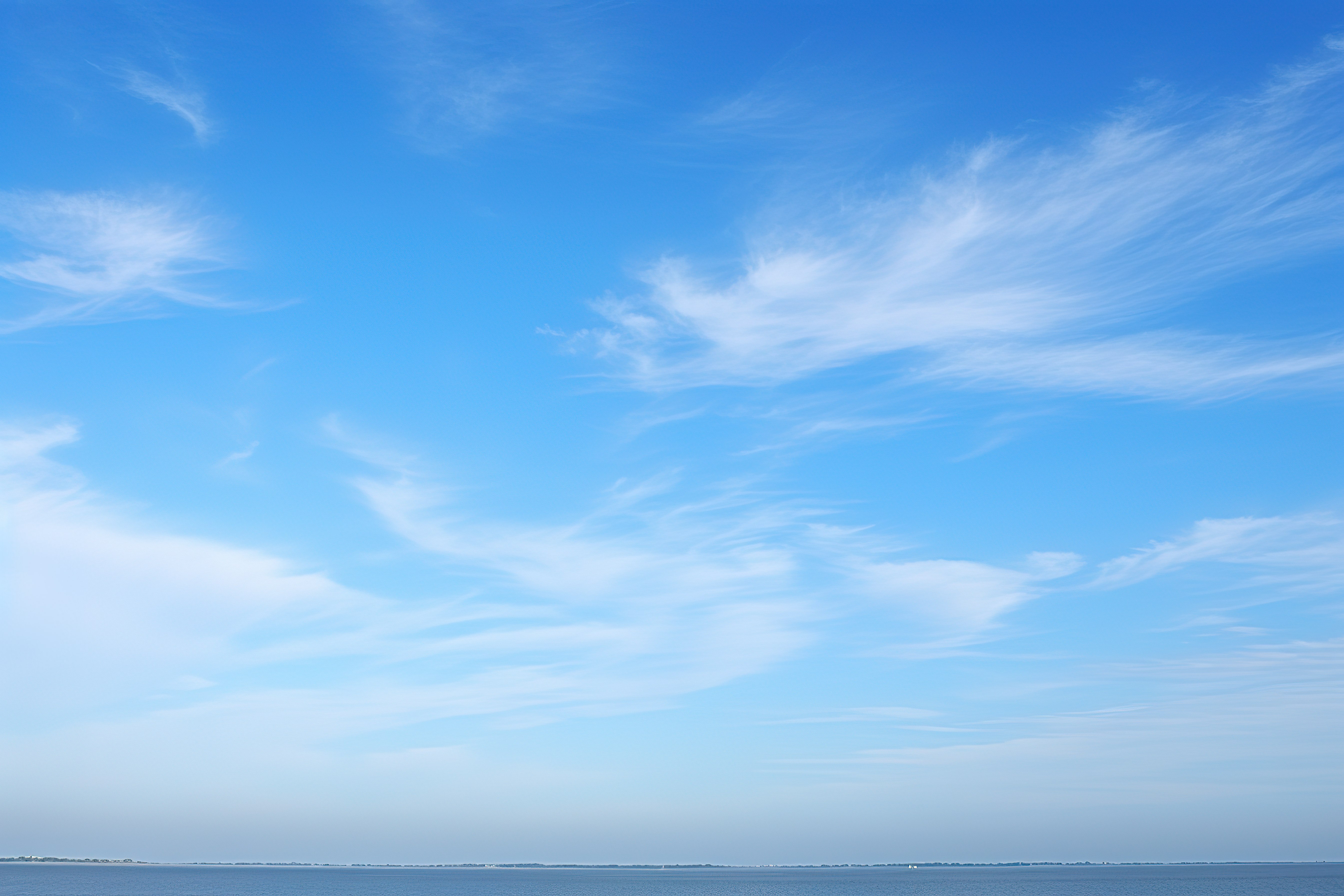 天蓝色的一天，有云海波浪和小船图片