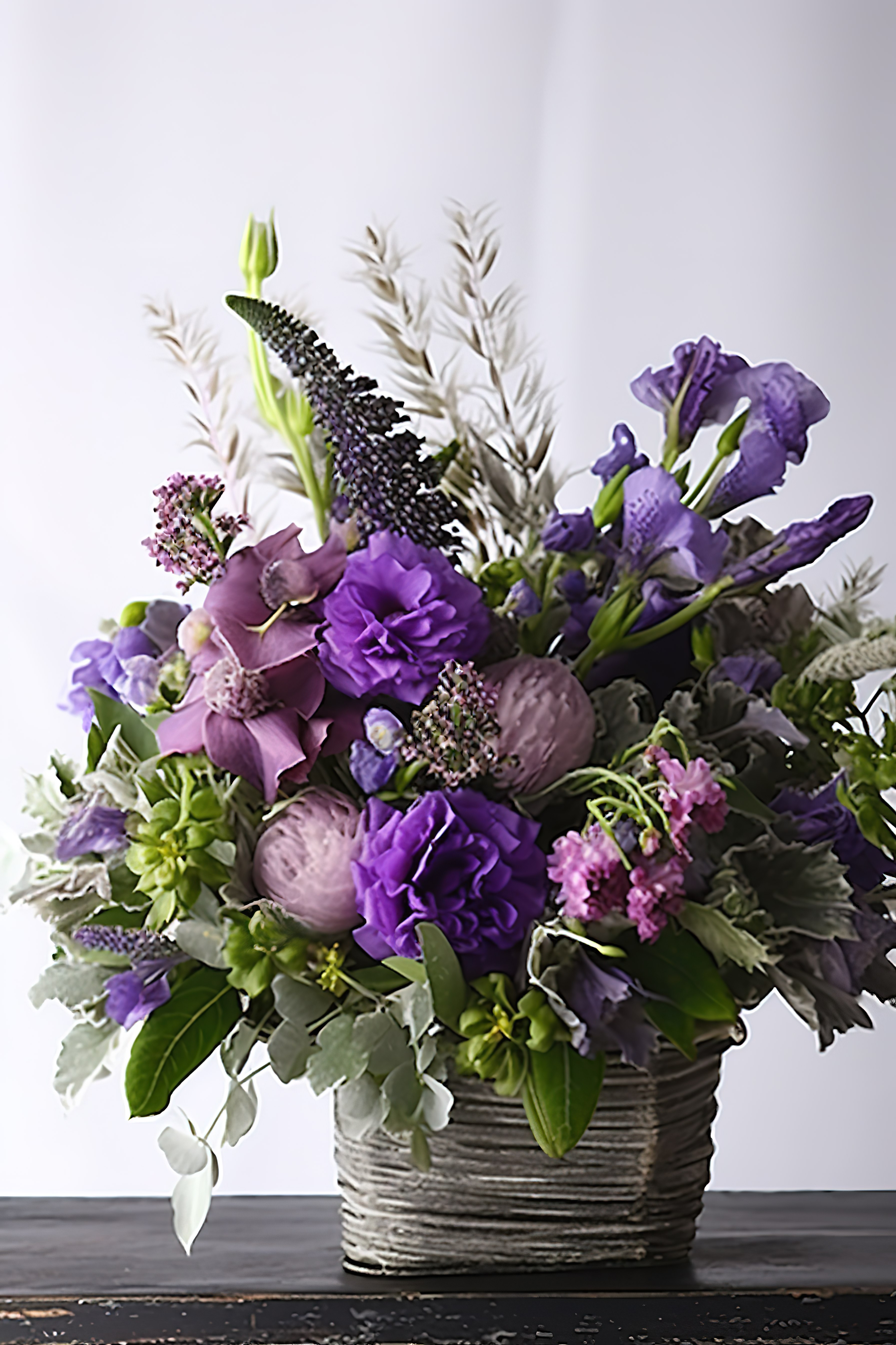 装满鲜花和绿色植物的紫色花篮图片