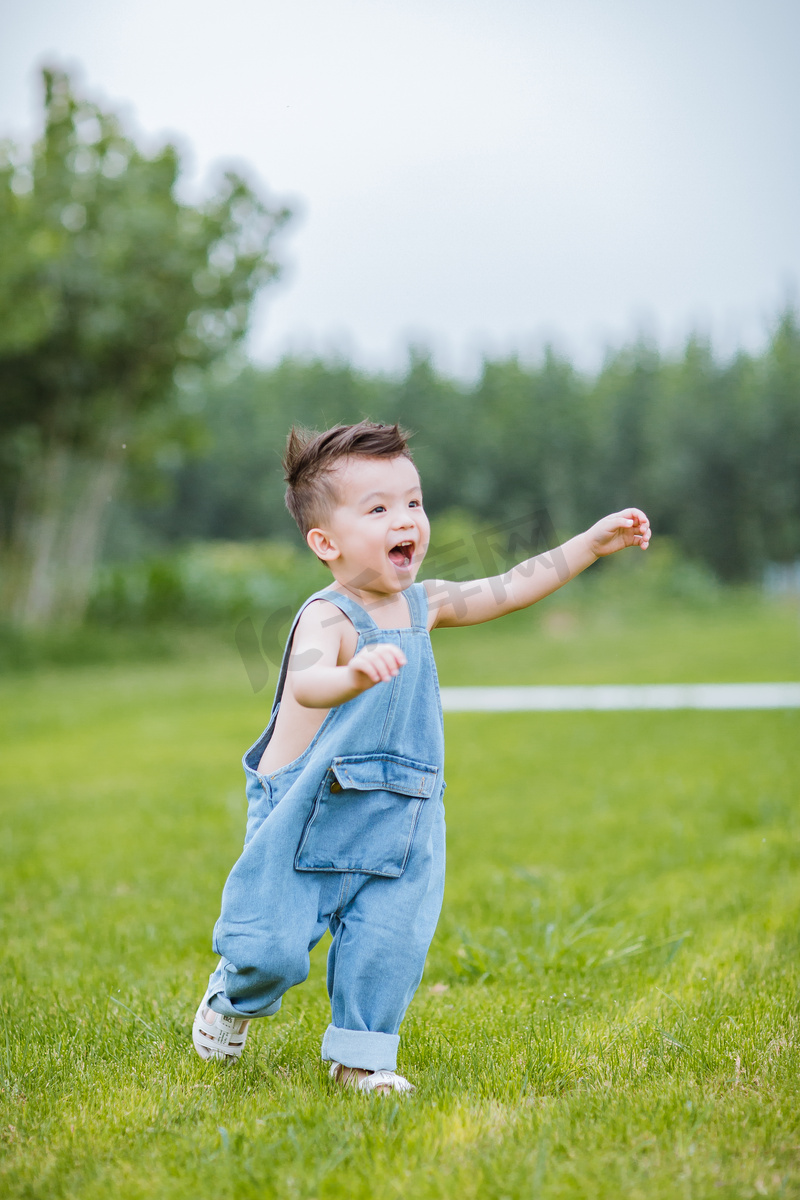 草地上奔跑的小男孩图片