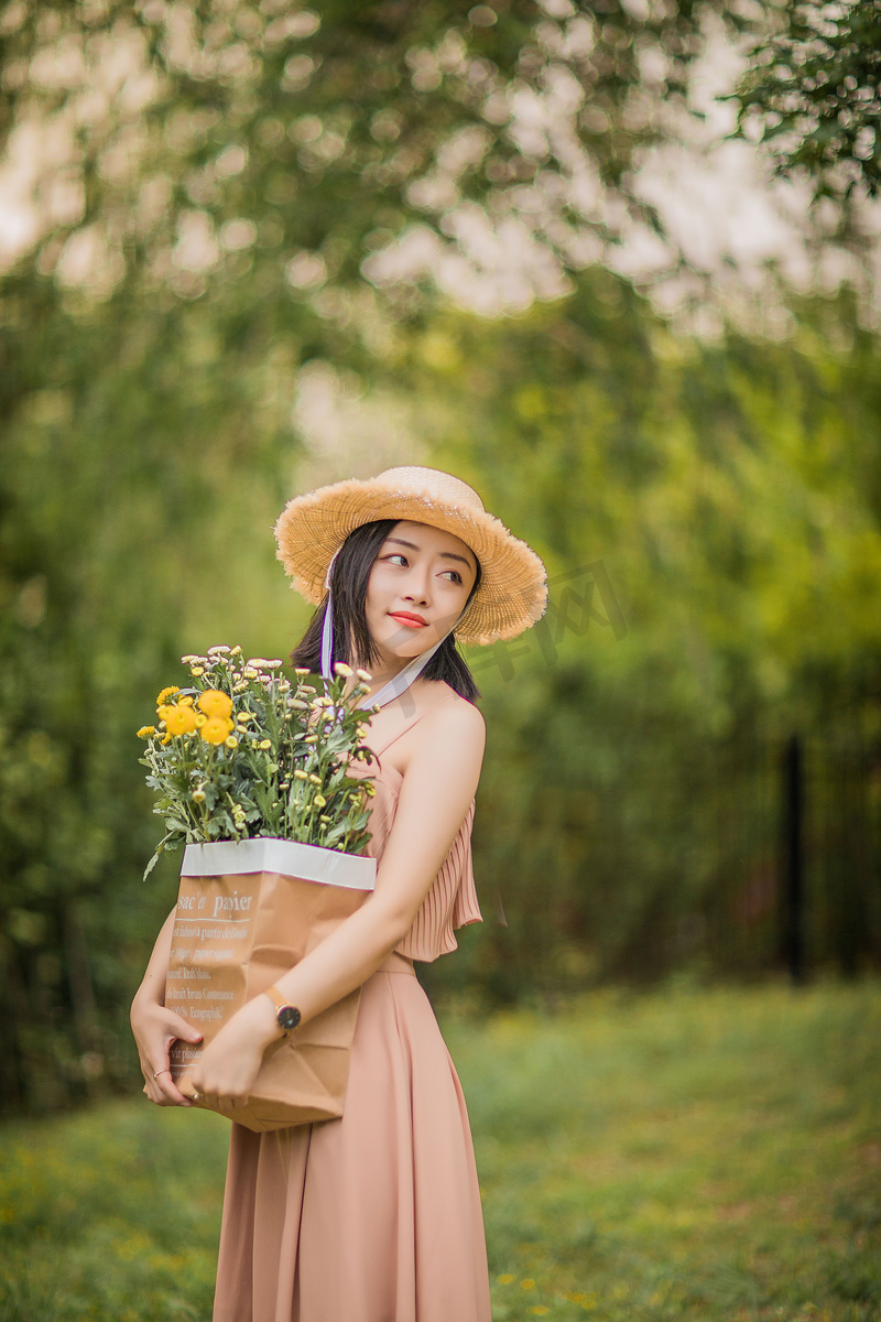 夏天户外抱着鲜花等人的女孩图片