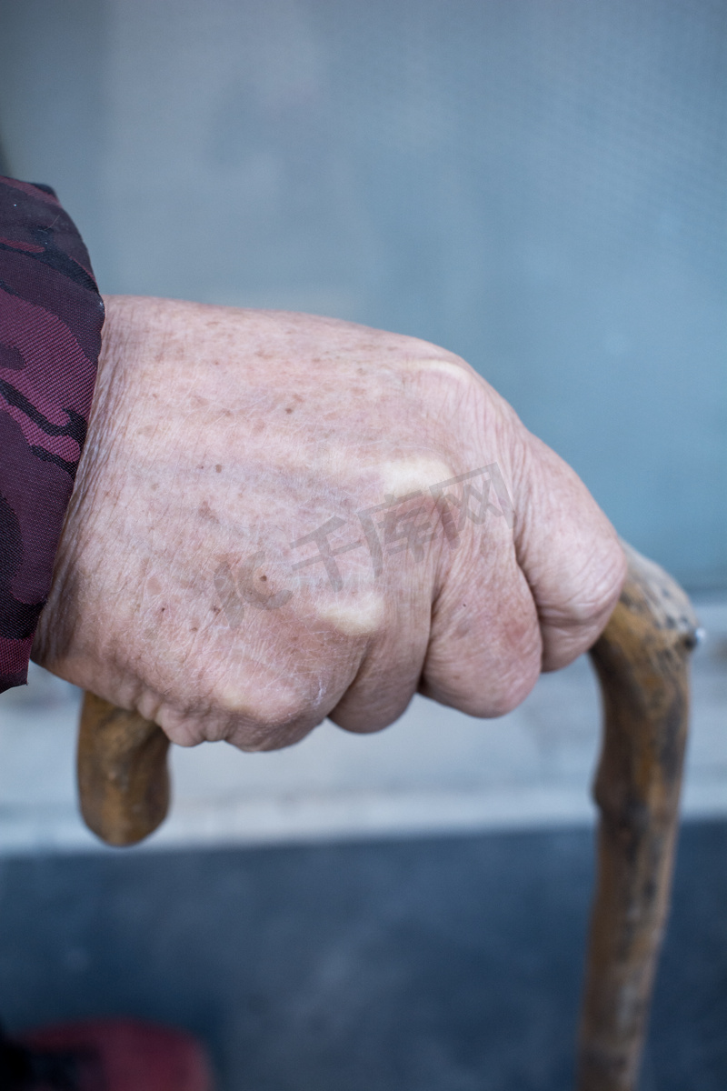 手握拐杖的老年人的手图片
