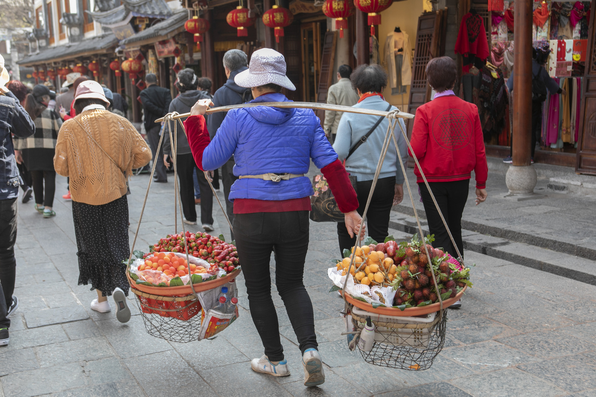 街道上挑水果挑担的人图片