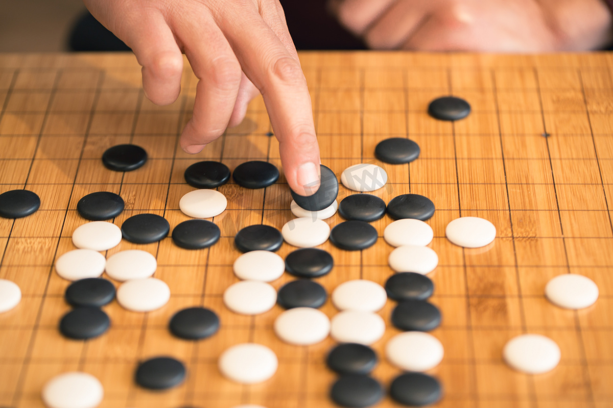 在棋盘上下围棋的手图片