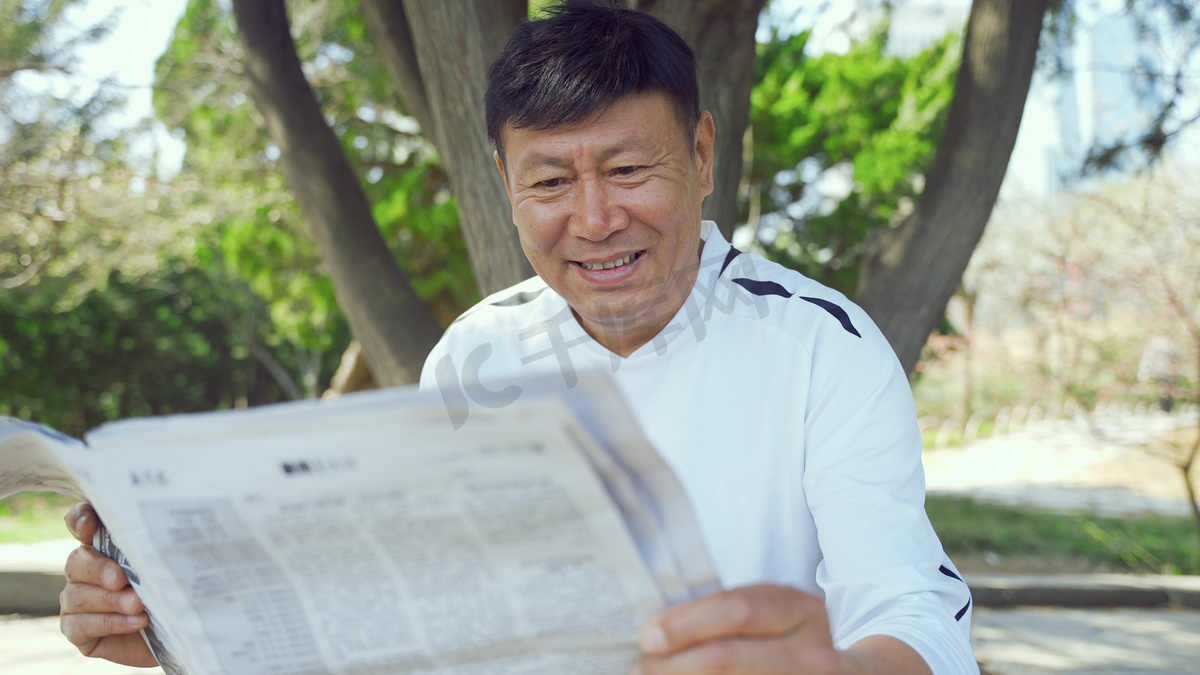 春天公园长椅老年人看报纸悠闲退休生活人像图片