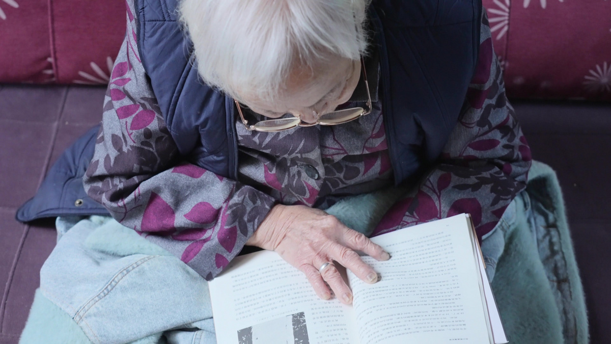 老年生活老人老太太戴老花镜阅读看书实拍图片