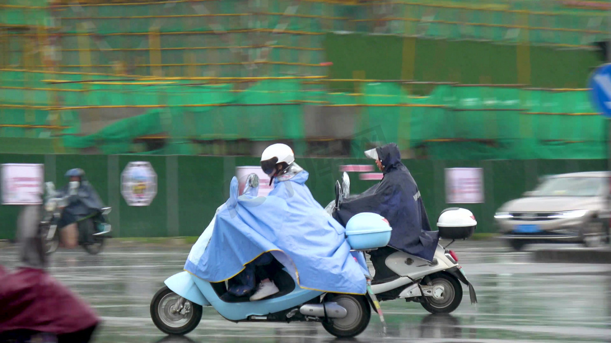 实况下雨天骑着电单车路口等待红绿灯的人们新闻素材图片