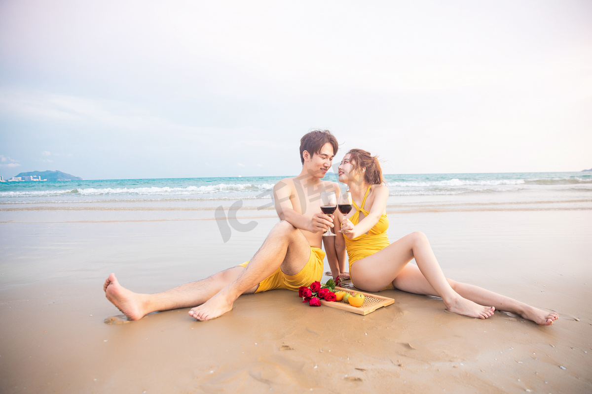 爱情蜜月白天一对喝红酒的情侣沙滩捧杯亲吻摄影图配图图片